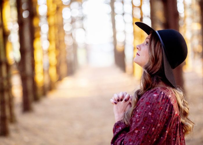 selective-focus-shot-beautiful-young-lady-praying-forest
